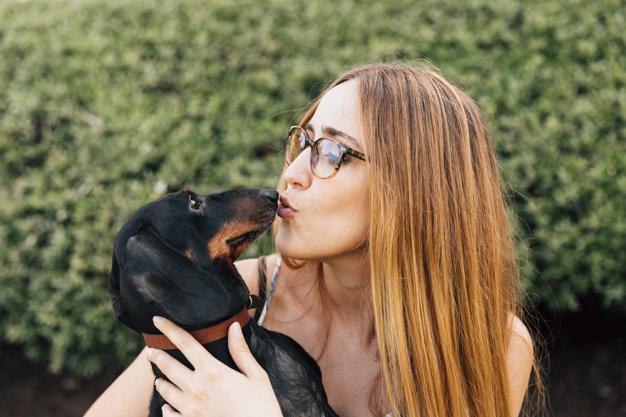 woman kissing dog